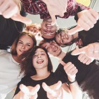 Happy group of friends with their hands together in the middle.